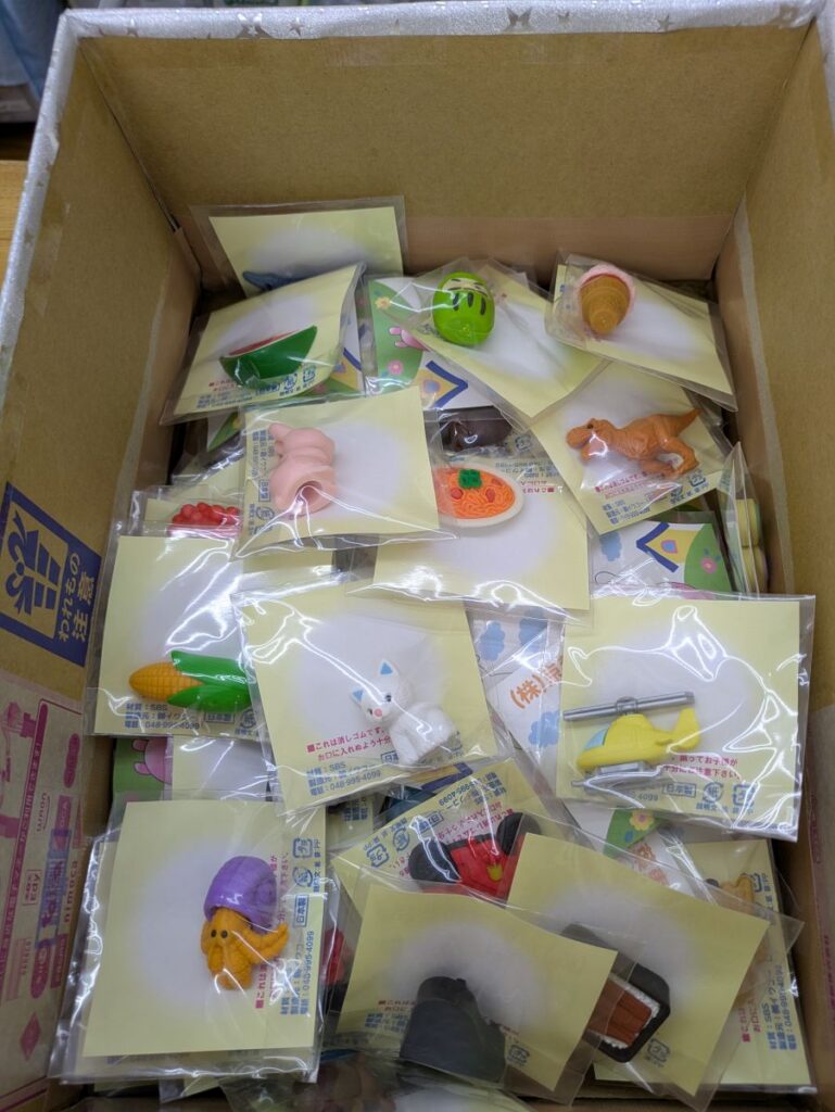 めぐみ薬局アルファー店のガチャガチャBOXに入っているさまざまな形の消しゴム