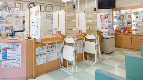 お薬お渡し口はパーテーションあり。ご相談時には椅子も利用できます。