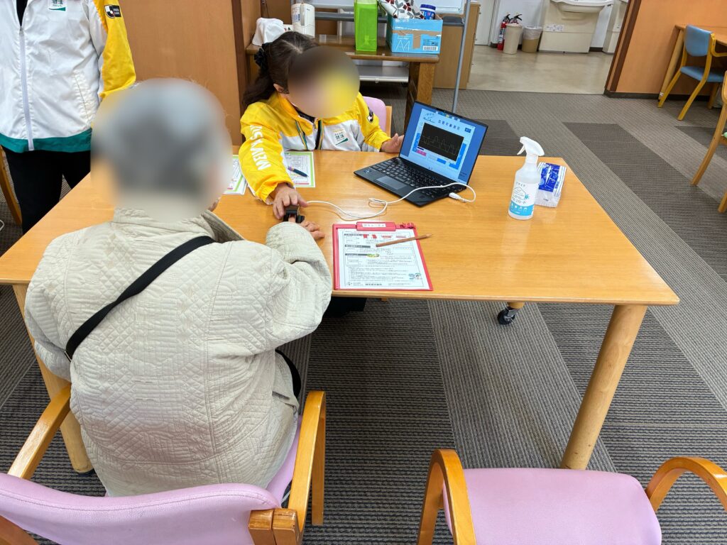 佐倉ゆうゆうの里にて、明治安田生命様のスタッフが血管年齢測定を行っている様子