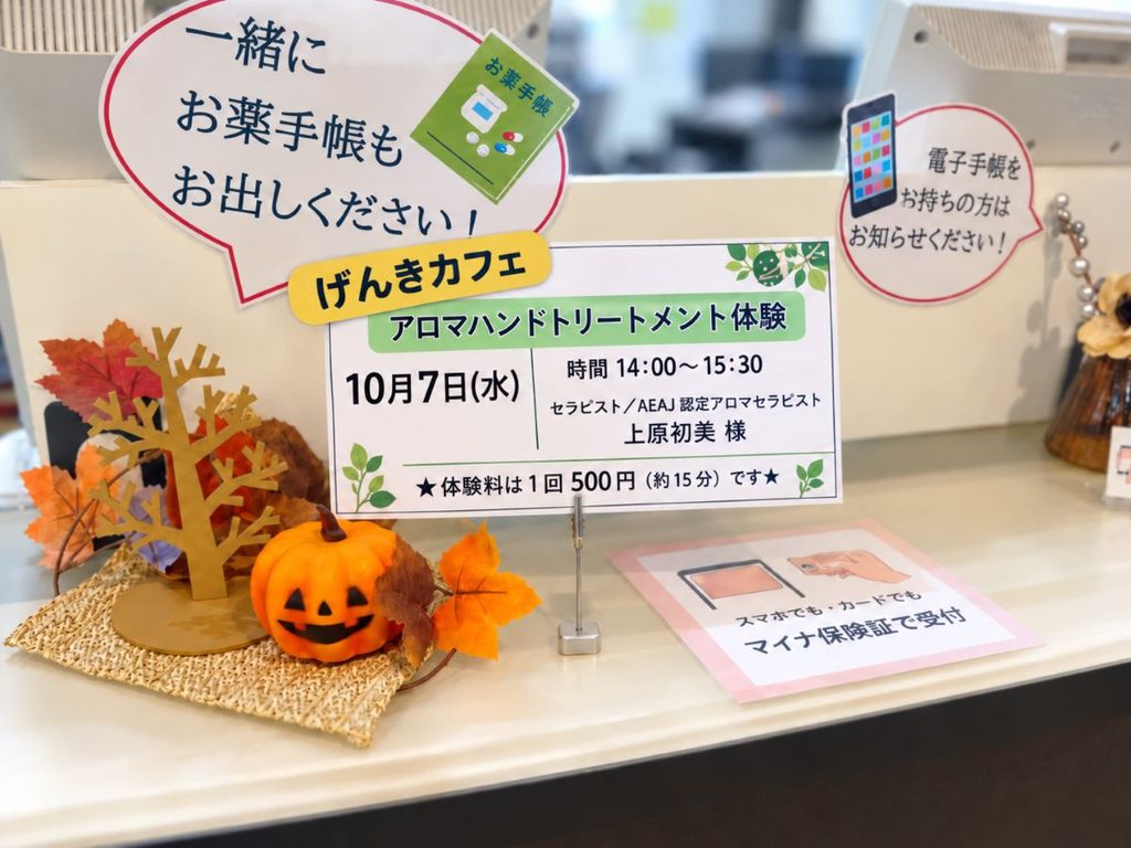 ファーマシーきみさらず受付の秋の飾りとげんきカフェやお薬手帳の案内