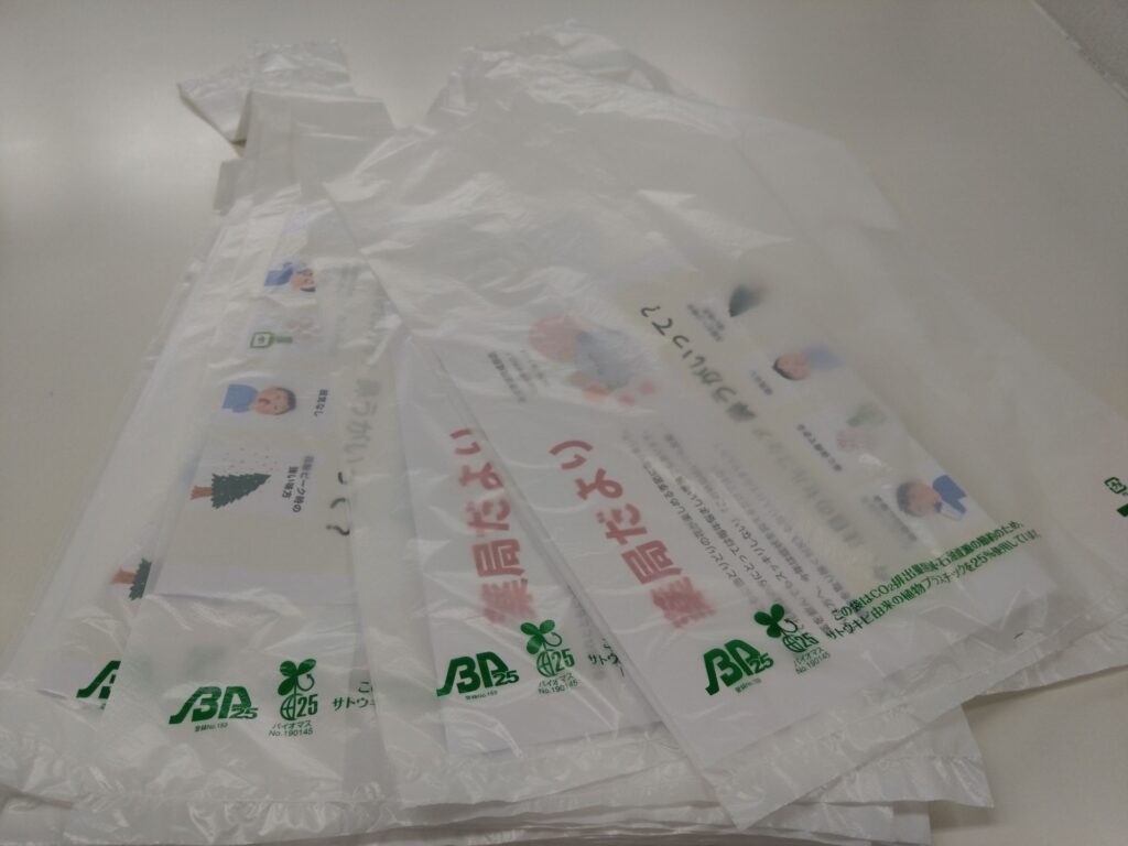 薬局だよりをレジ袋に入れて配布している様子（みずき薬局成田店）