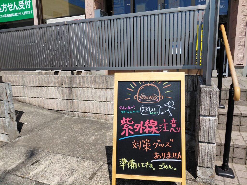 ひまわり薬局戸頭店の入口に設置された紫外線注意の手書きA看板
