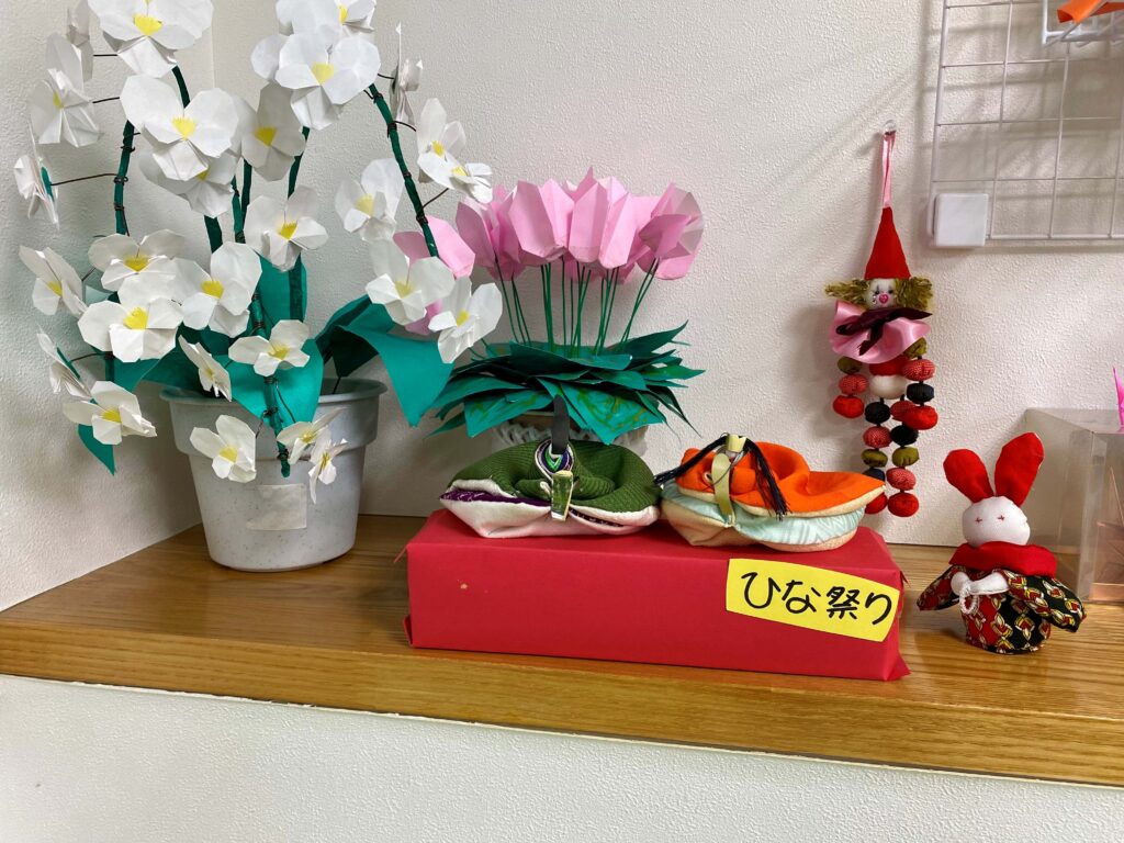 薬局の店内に飾られた手作りのお雛様と季節の飾り
