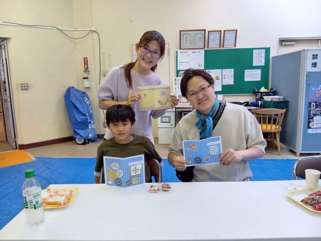 ファミリー薬局東陽町店のお薬手帳カバーづくりイベントで完成したカバーを持つ参加者