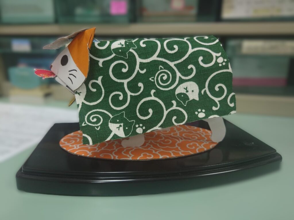 ひまわり薬局豊四季駅前店のカウンターに飾られた獅子舞衣装の猫人形