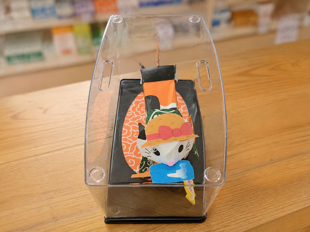 無ぐわら帽子をかぶりアイスをくわえた手作りの猫を上から見た様子