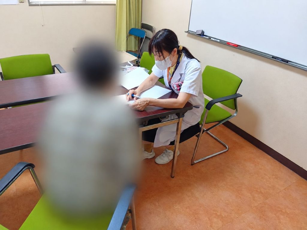 資料を確認しながら健康相談を行う薬剤師